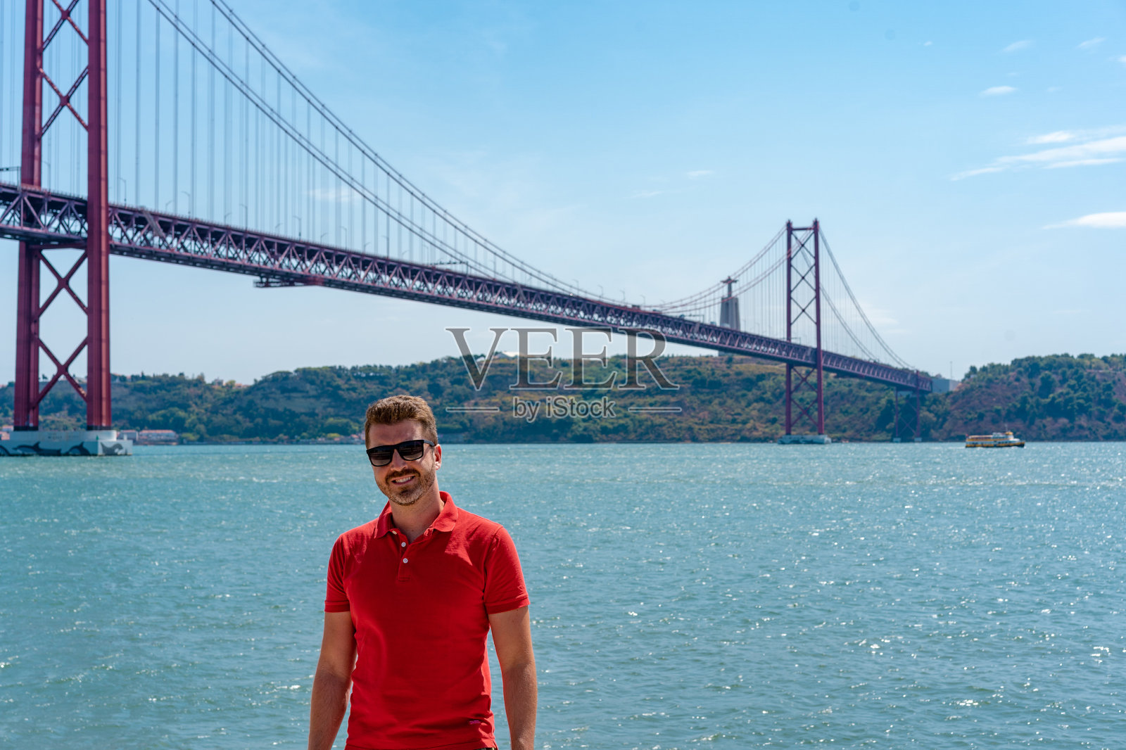 在里斯本著名钢桥前摆姿势的年轻男人照片摄影图片