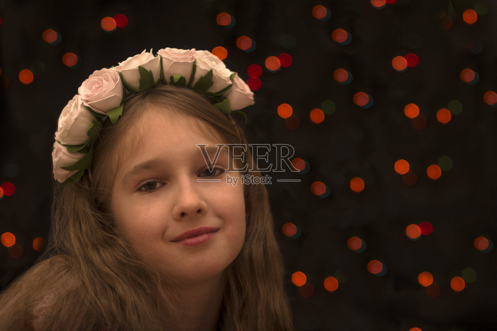 一位美丽的年轻姑娘饶有兴趣地把目光移开。黑色背景与散景。副本的空间。照片摄影图片