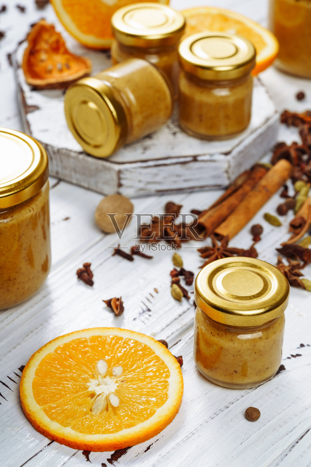 橘子酱玻璃瓶，肉桂棒和坚果照片摄影图片