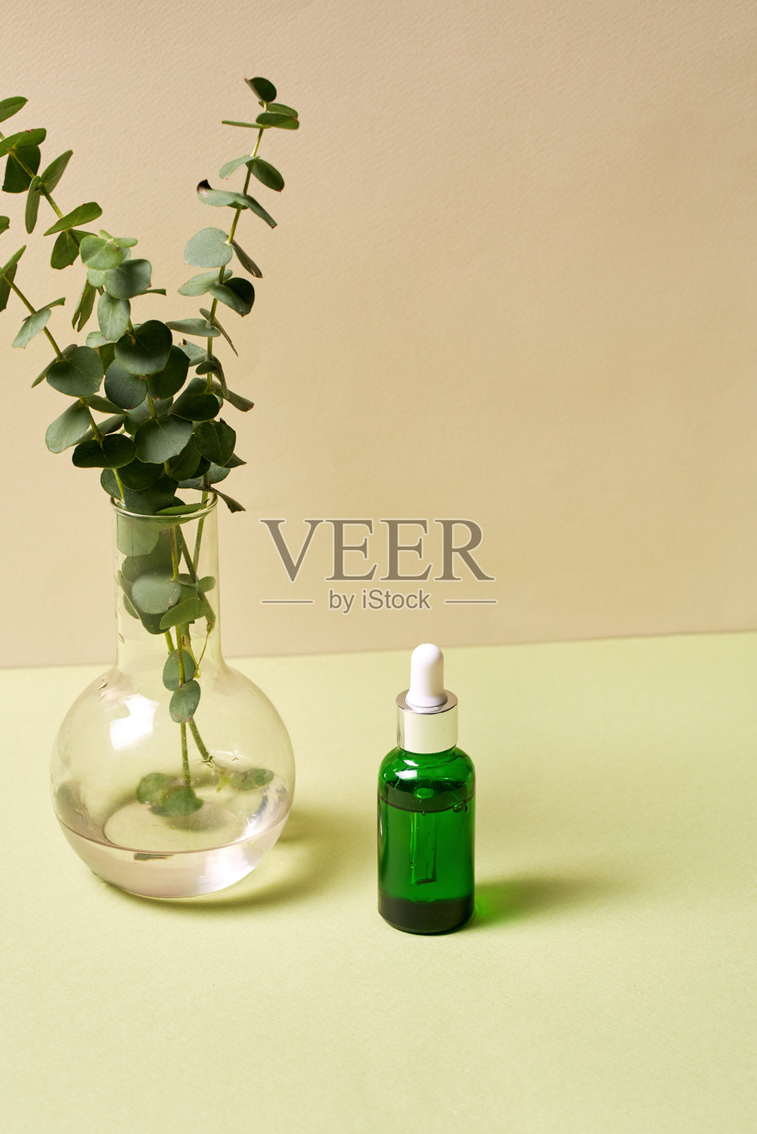 带移液管的血清油瓶，放置在有植物的花瓶旁照片摄影图片