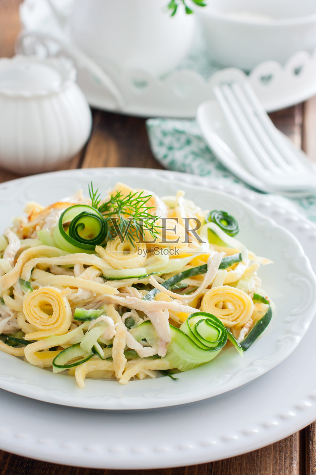 白盘子上有新鲜黄瓜沙拉，鸡肉和煎蛋煎饼，有选择的重点照片摄影图片