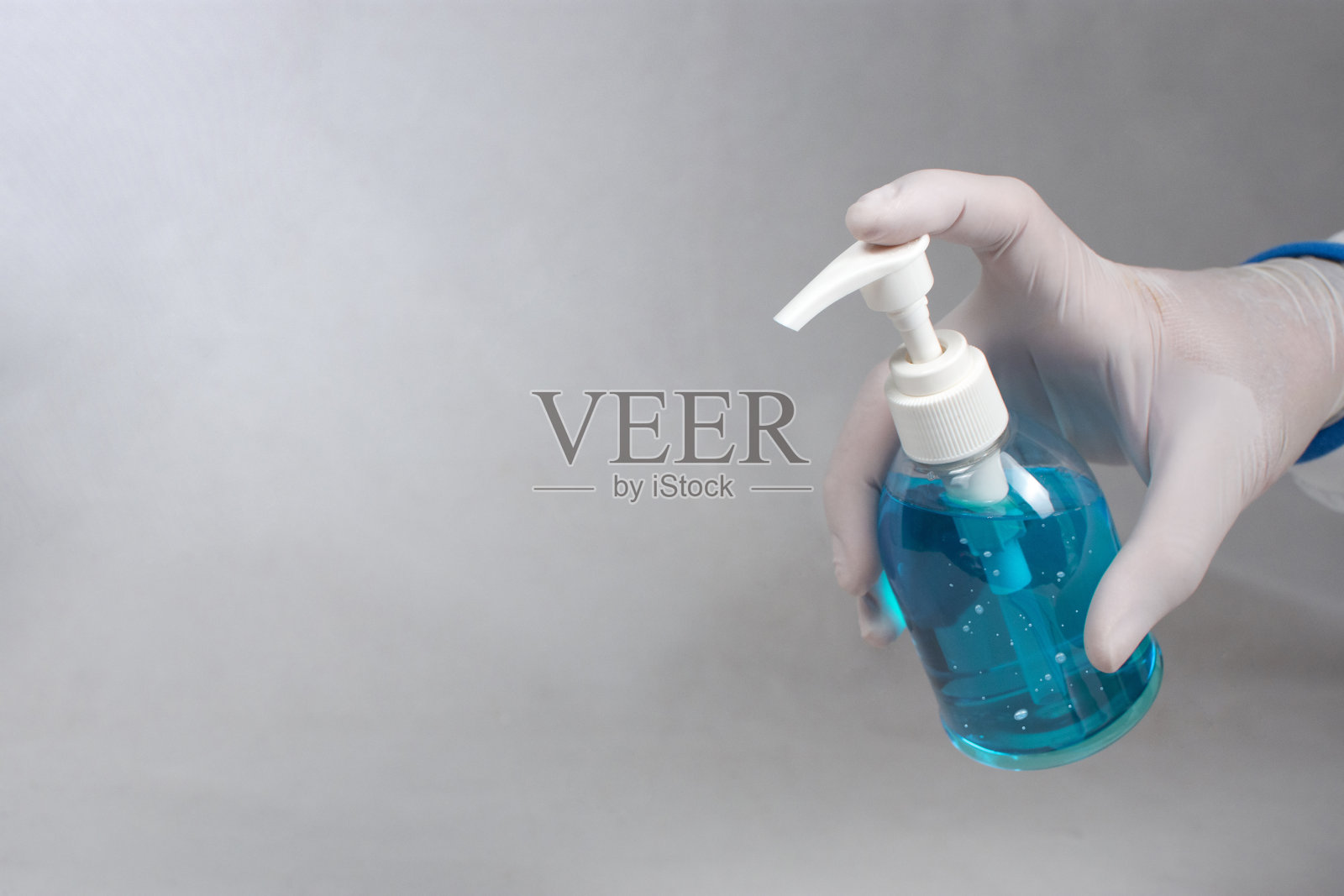 预防Covid-19病毒，用医生手中的酒精消毒剂瓶预防感染。照片摄影图片