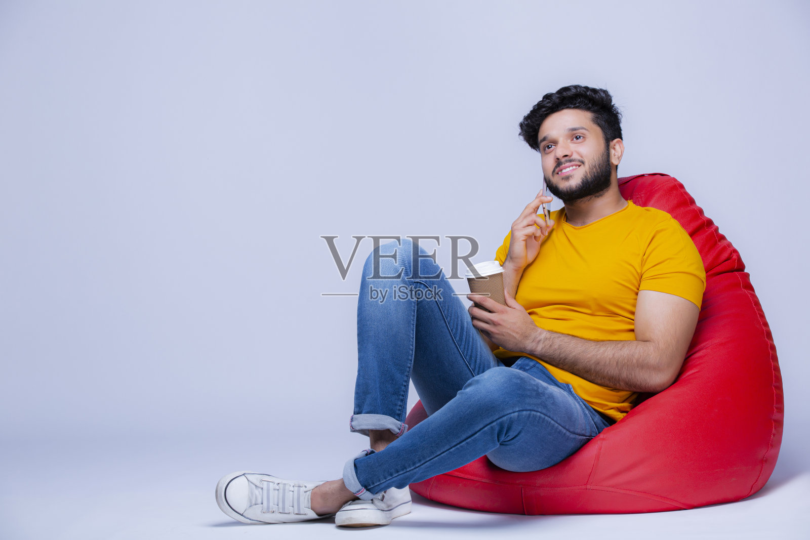 年轻人放松在豆袋椅上的白色背景股票照片照片摄影图片