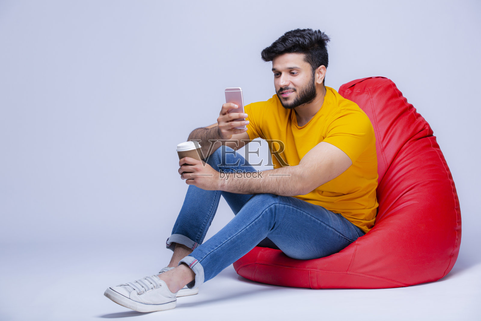 年轻人放松在豆袋椅上的白色背景股票照片照片摄影图片