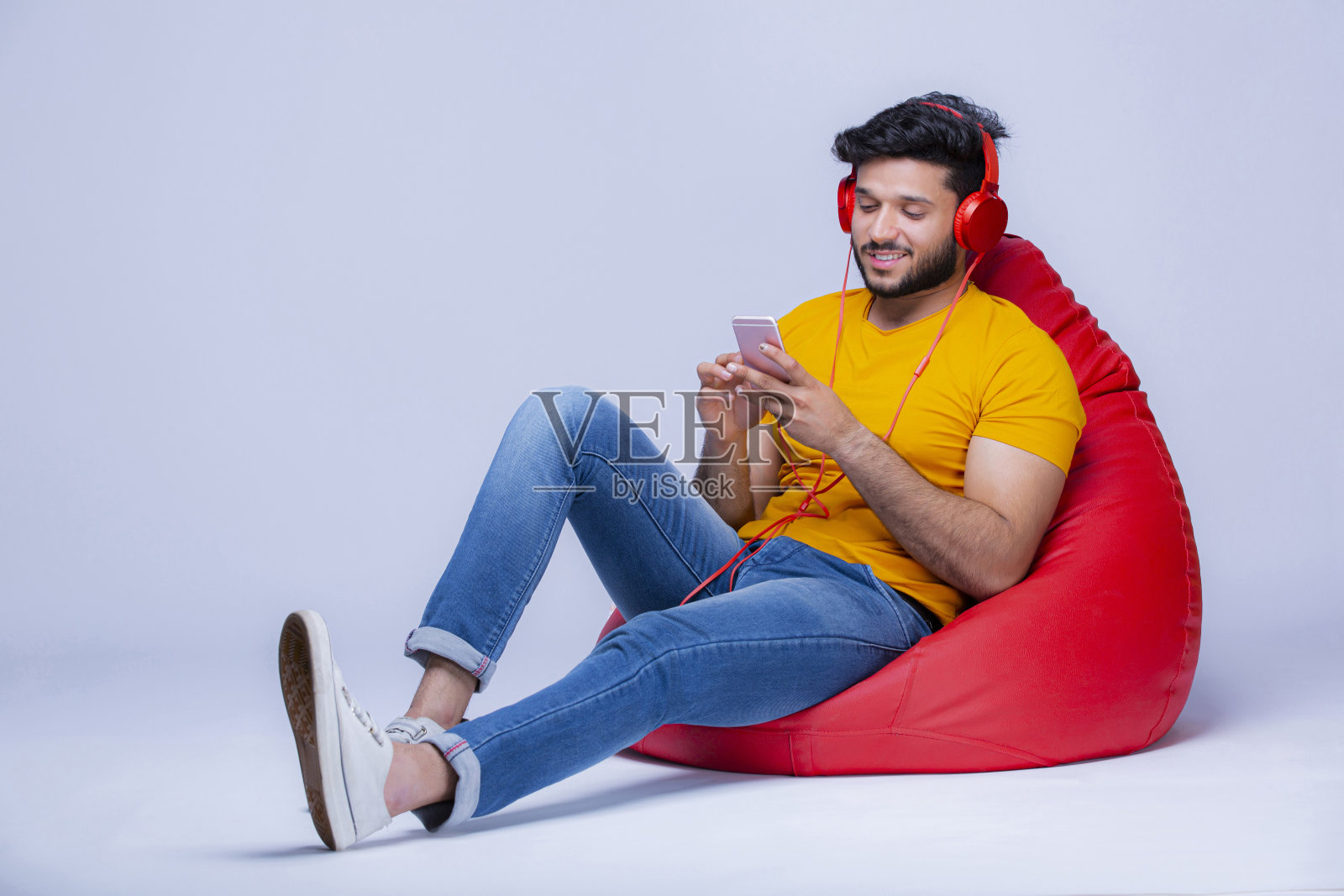 年轻人放松在豆袋椅上的白色背景股票照片照片摄影图片