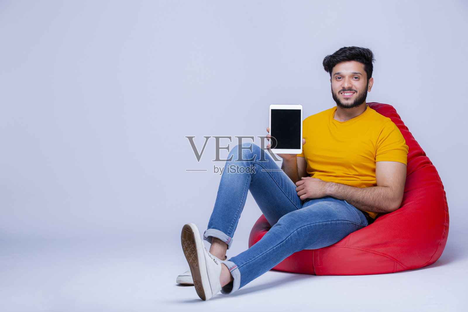 年轻人放松在豆袋椅上的白色背景股票照片照片摄影图片