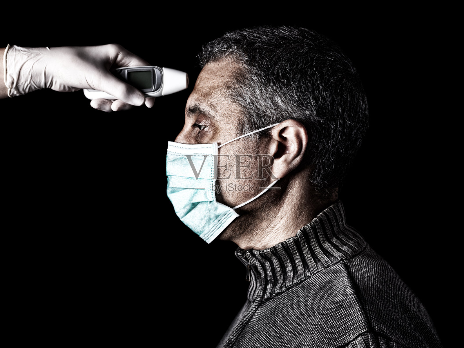 护士用数字温度计为男人测量体温。疫情或流行病，恐惧或危险概念。针对COVID-19等生物危害的防护照片摄影图片