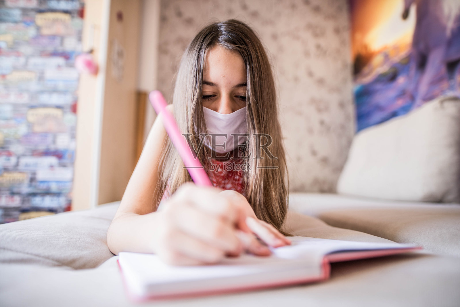 小女孩戴着医用防护口罩做作业照片摄影图片