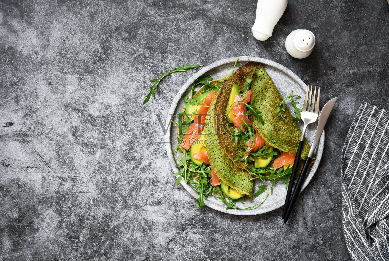 厨房桌子上有菠菜、鲑鱼和奶酪煎饼。从以上观点。照片摄影图片