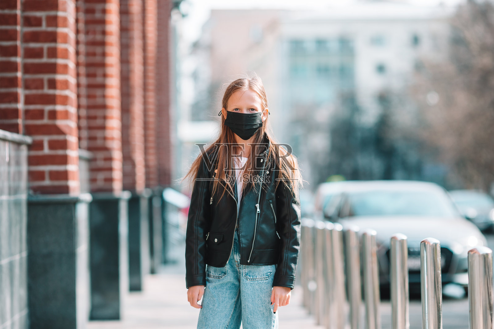 戴口罩的女孩，背景是现代建筑照片摄影图片