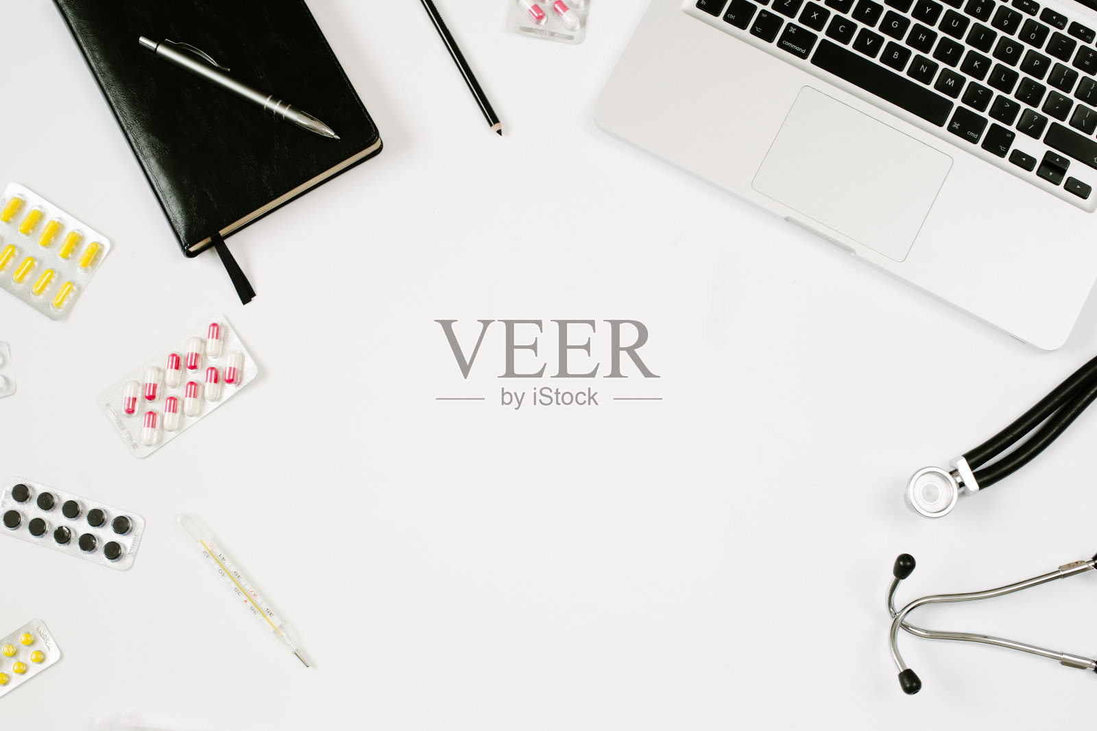 医生工作的地方，桌子上有复印空间，听诊器，笔记本电脑，笔记本电脑和药片。医学和流行概念。平躺风格照片摄影图片