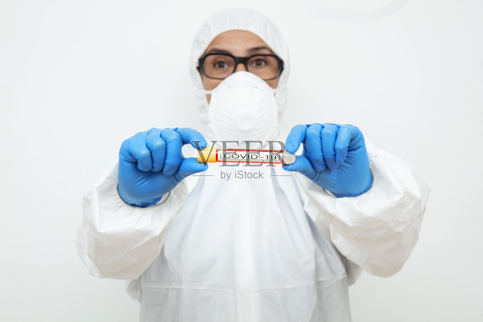 睁大眼睛的护士拿着装有血液的试管进行2019-nCoV分析，疫情概念照片摄影图片