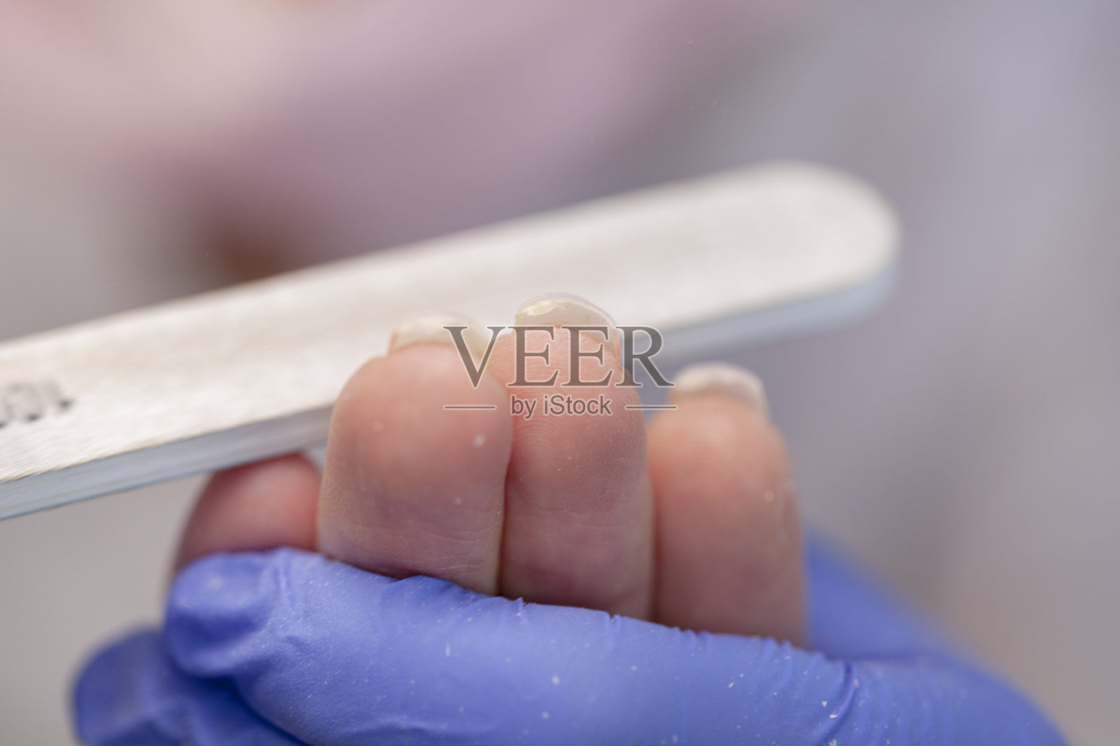 专业美甲。一个女人在美甲沙龙的特写镜头。用指甲锉修指甲，特写照片摄影图片