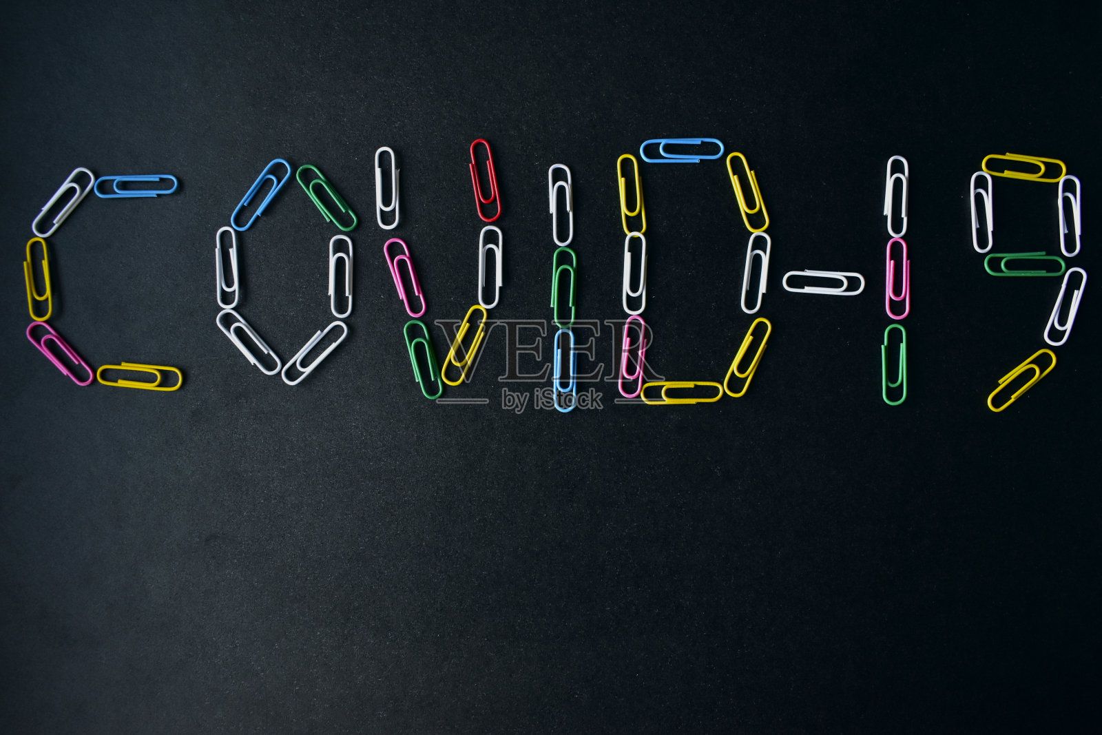 Covid-19病毒，黑色背景上有彩色回形针照片摄影图片