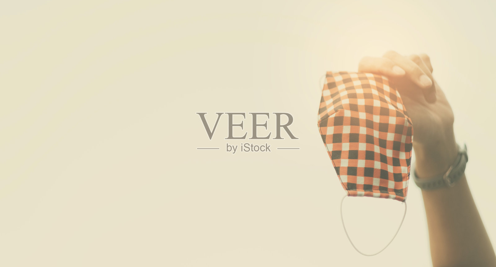 手拿口罩在天空，害怕病毒，COVID-19照片摄影图片