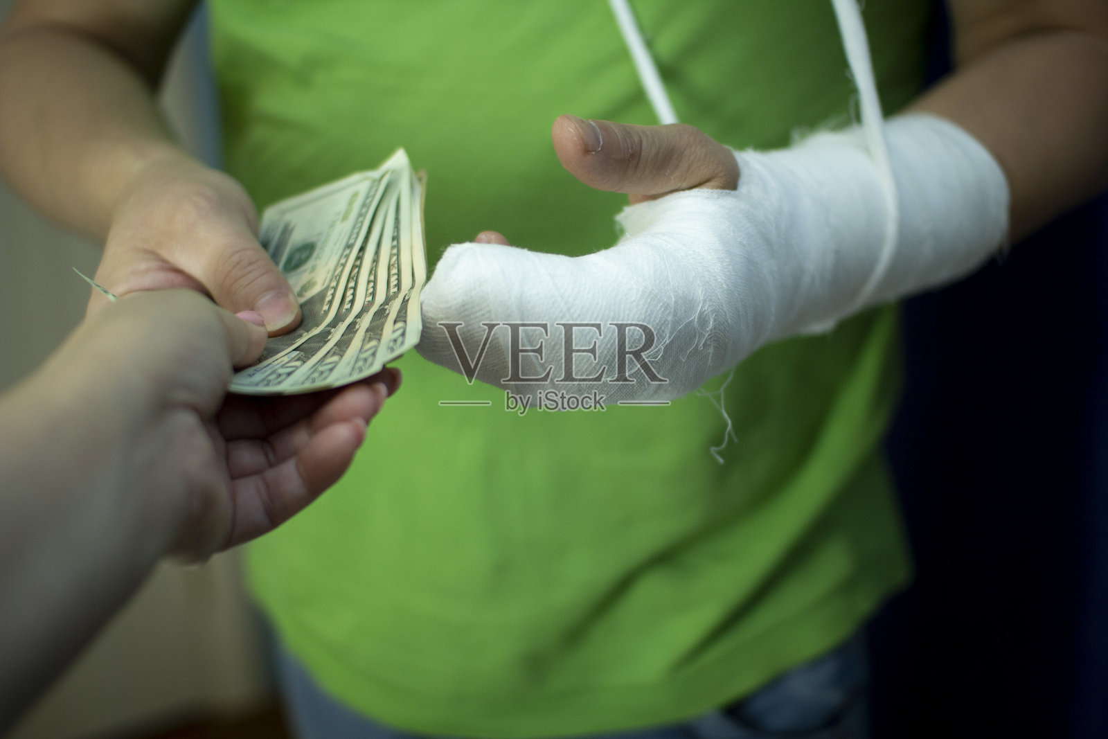 一个打着石膏的人从医院的急救费用中省下了一笔钱。照片摄影图片