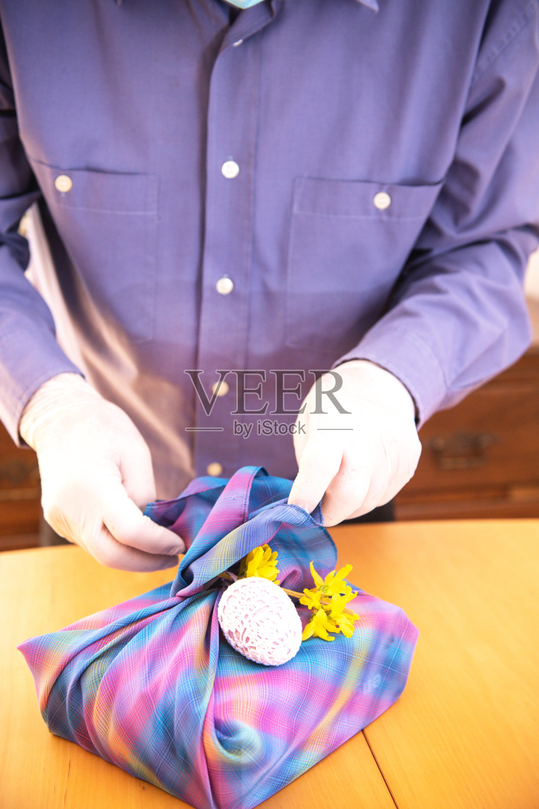 戴着口罩制作风吕敷的年长男人（隔离期间的复活节）照片摄影图片