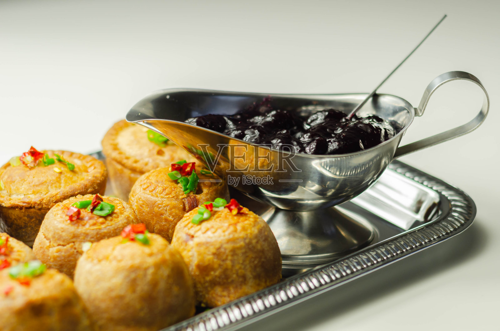 传统的英国猪肉馅饼和蔓越莓酱放在银托盘上照片摄影图片