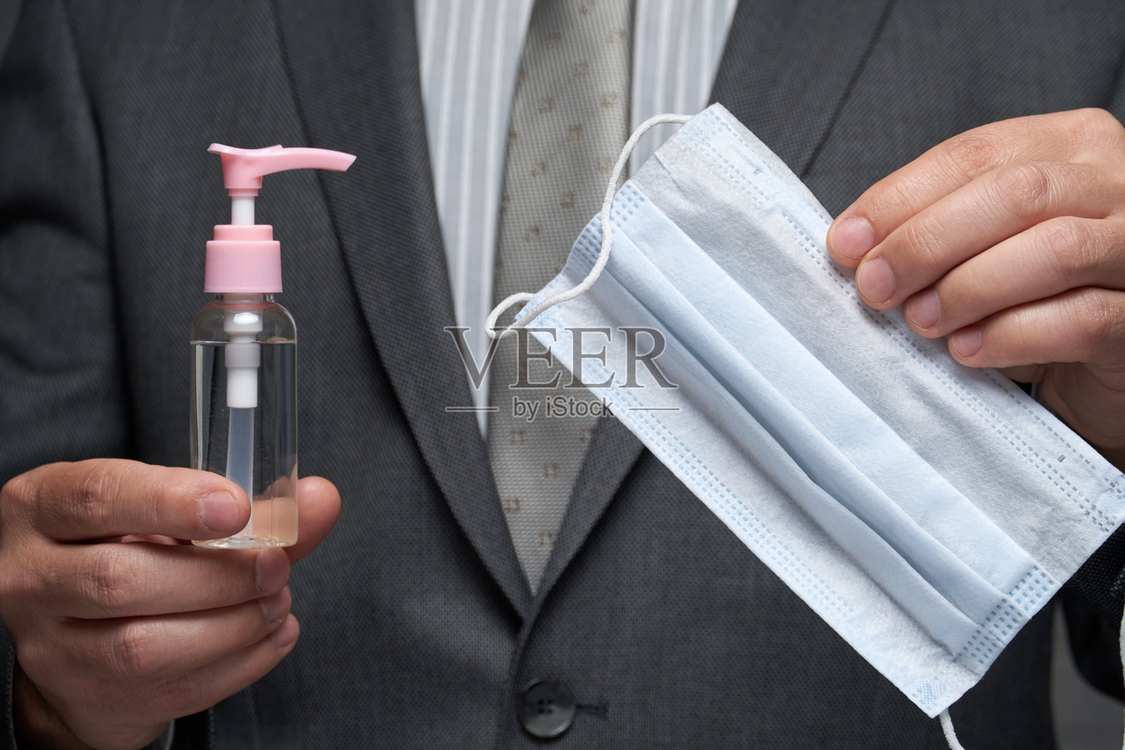 男子演示防病毒口罩和消毒液，提供个人防护建议照片摄影图片