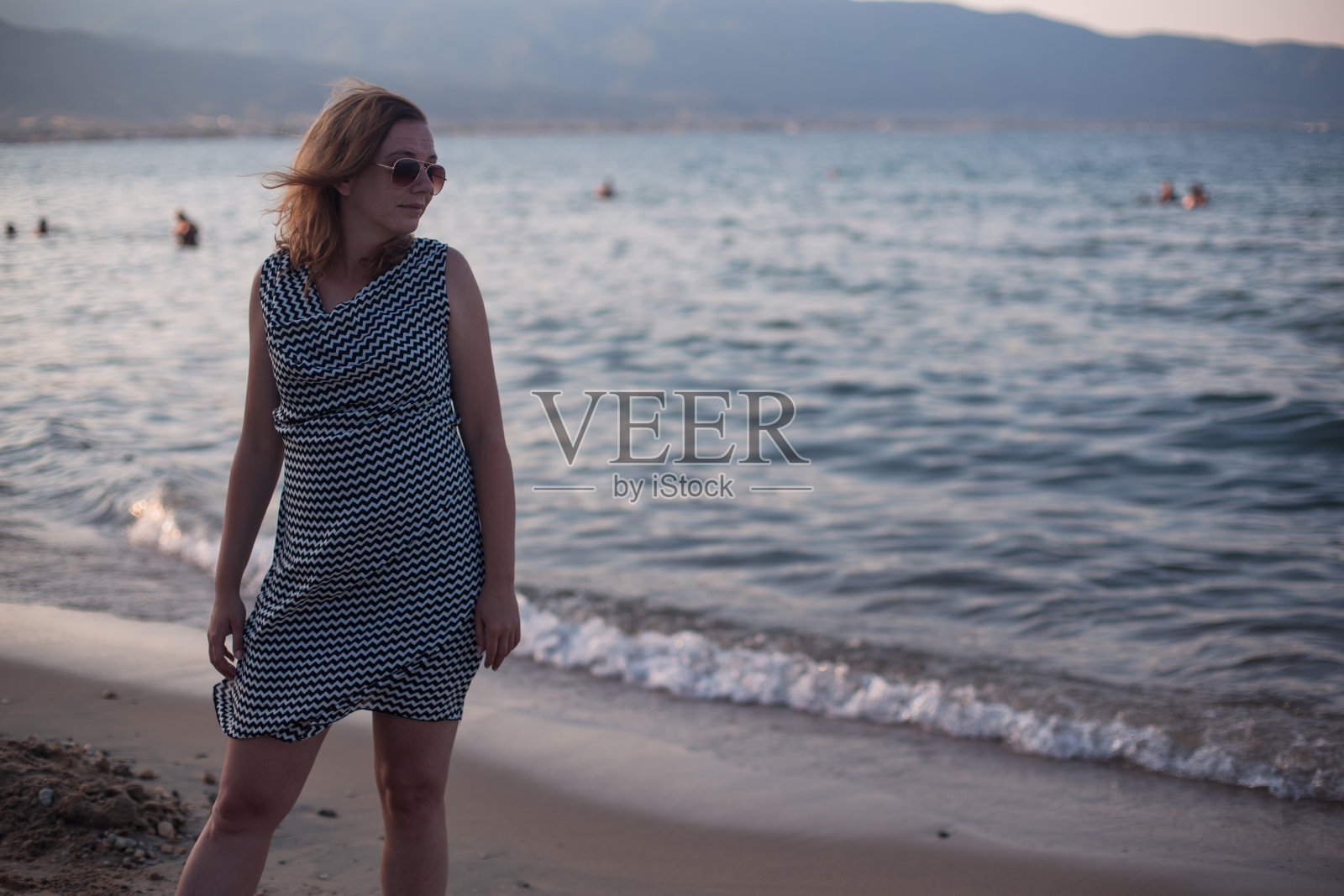 在海滩上散步的美丽女人照片摄影图片