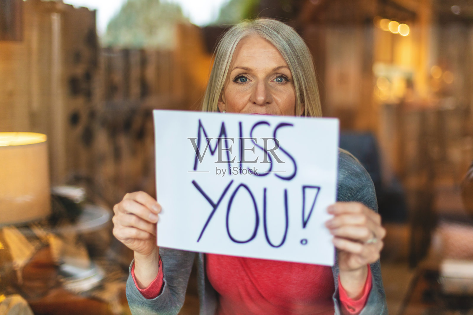 在空气传播疾病危机期间，在隔离期间，成熟女性在家避难所手持标志图像系列照片摄影图片