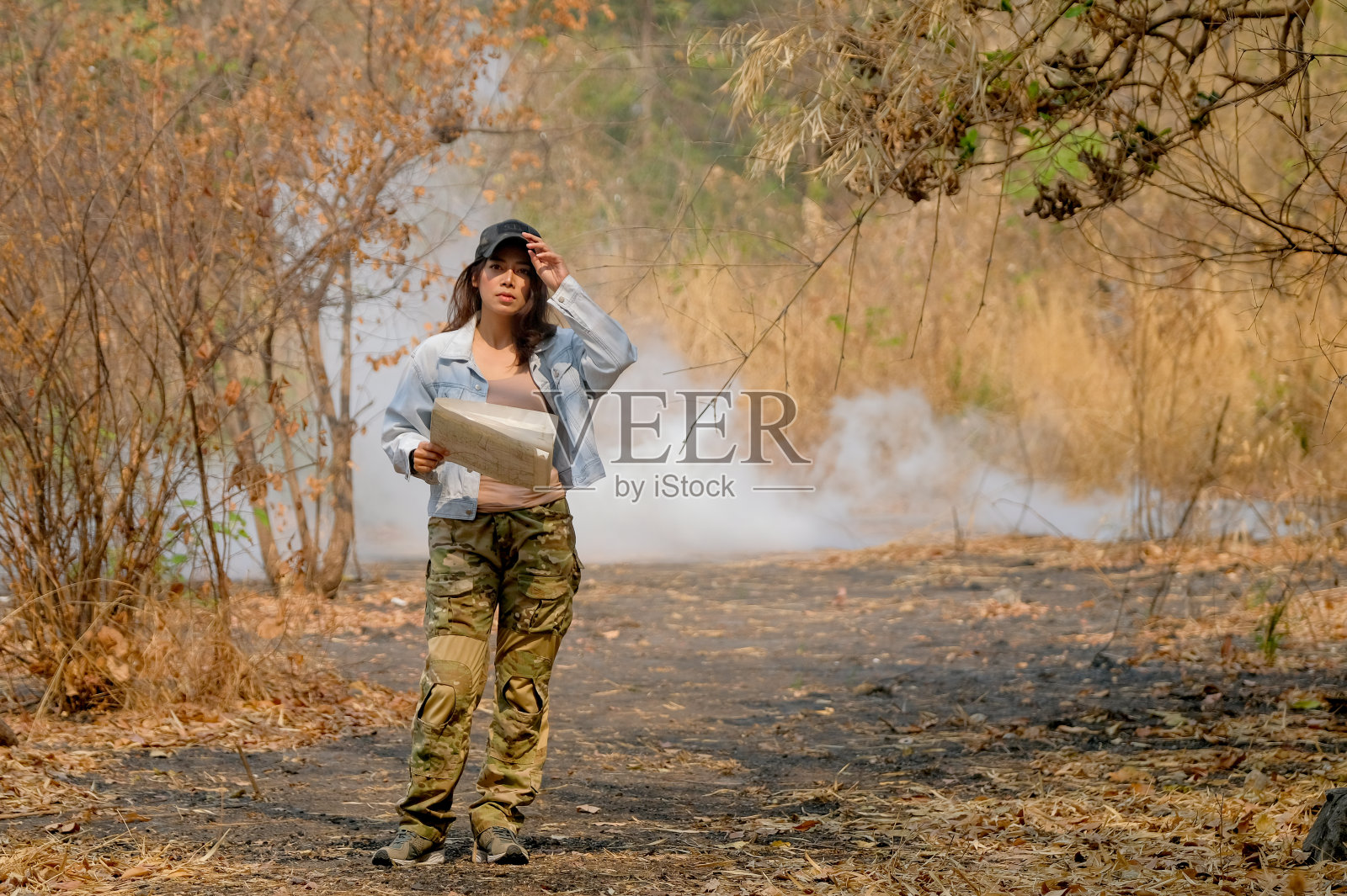 模糊的女孩肖像，手持地图，迷失在丛林中照片摄影图片