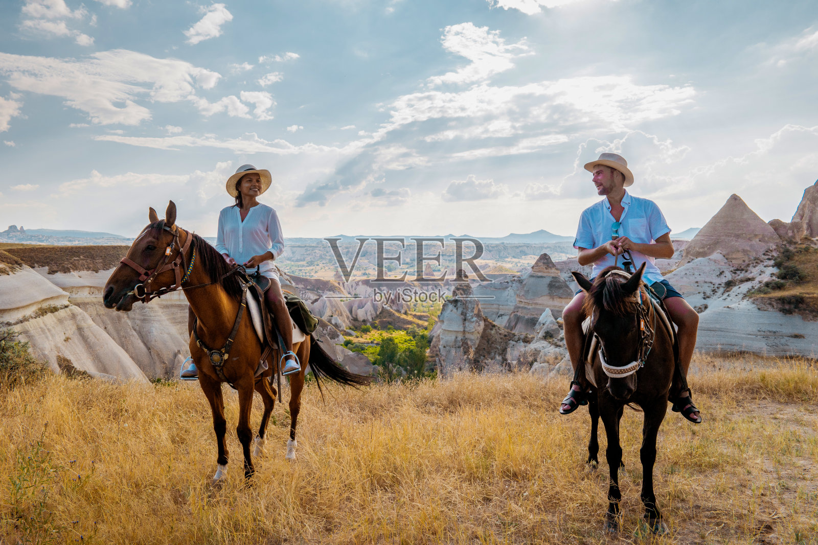 在土耳其卡帕多奇亚度假的年轻夫妇观看热气球照片摄影图片
