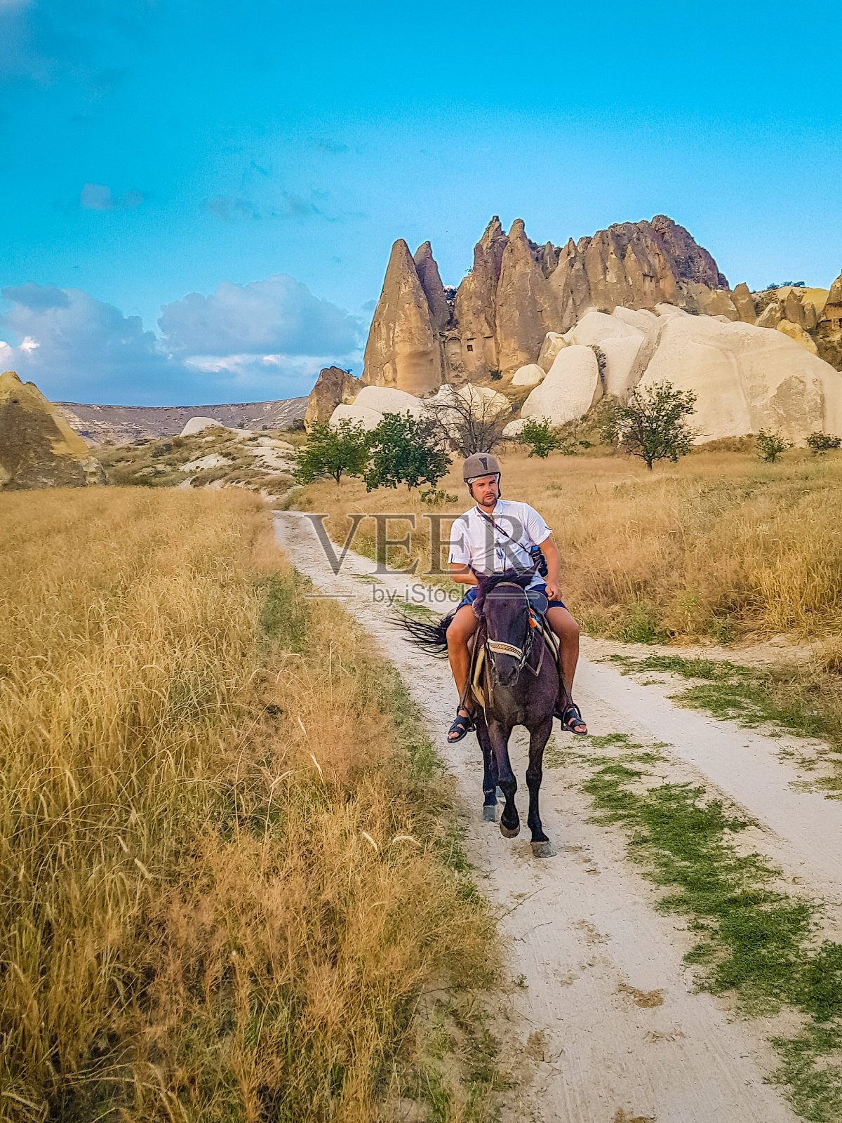 在土耳其卡帕多奇亚度假的年轻夫妇观看热气球照片摄影图片