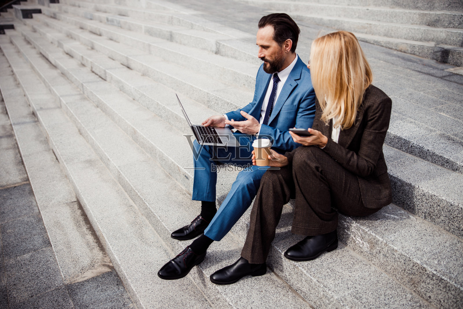 两个商业伙伴坐在楼梯上照片摄影图片
