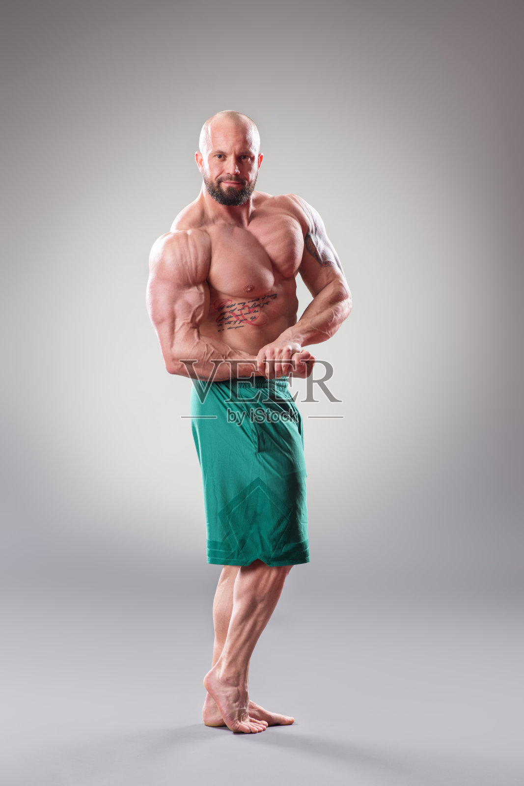 健壮的男人在灰色背景下摆姿势照片摄影图片