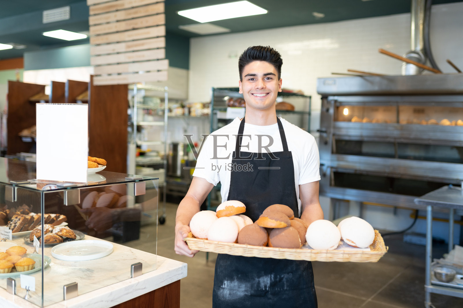 面包师展示一盘甜面包照片摄影图片