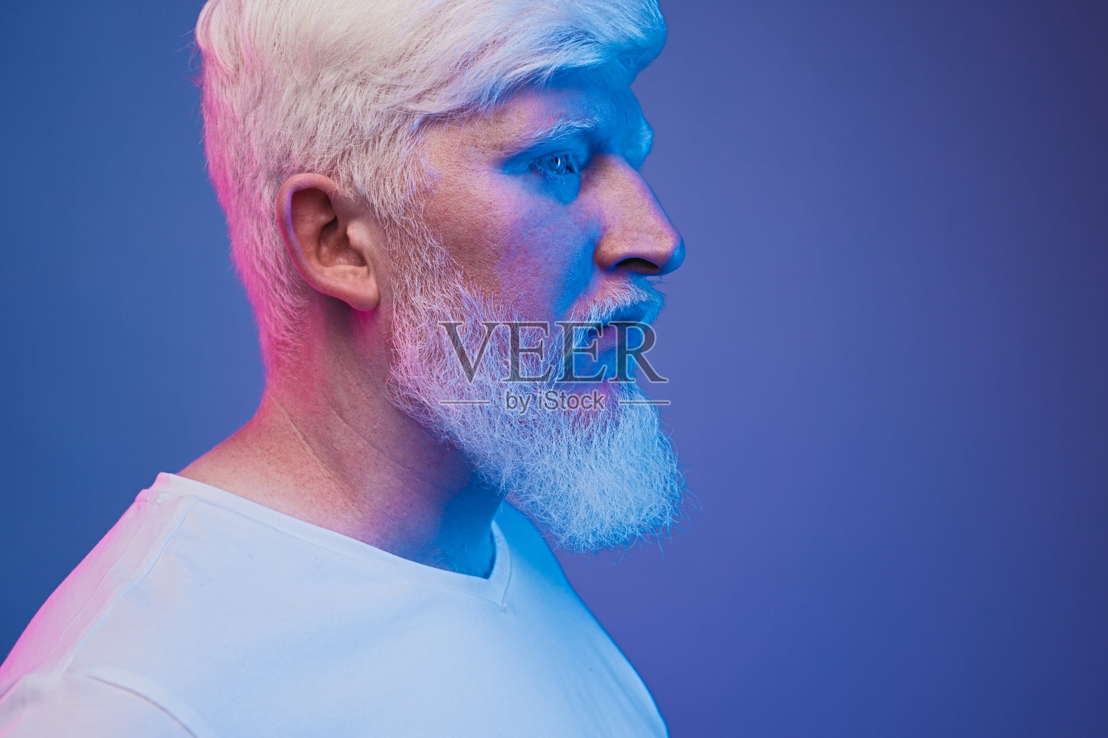 霓虹灯下的面无表情的白化病男子照片摄影图片