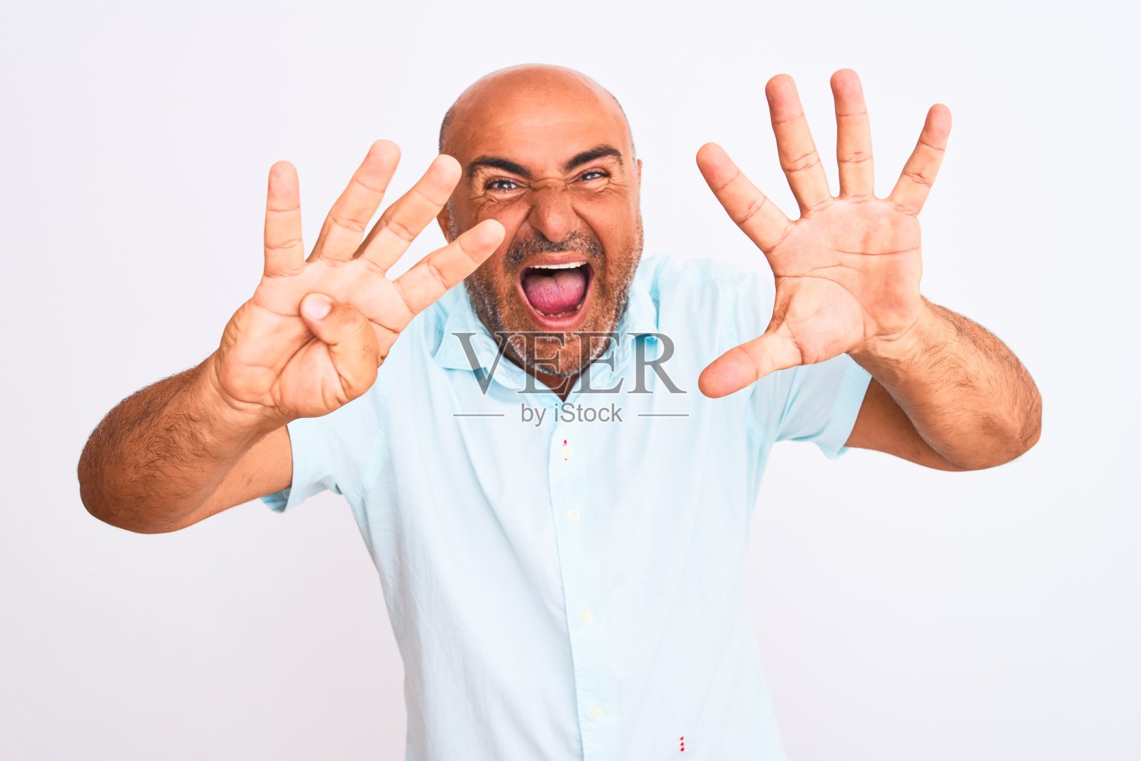 穿着休闲衬衫的中年男子，面带微笑，用手指指着上方，比出数字九照片摄影图片