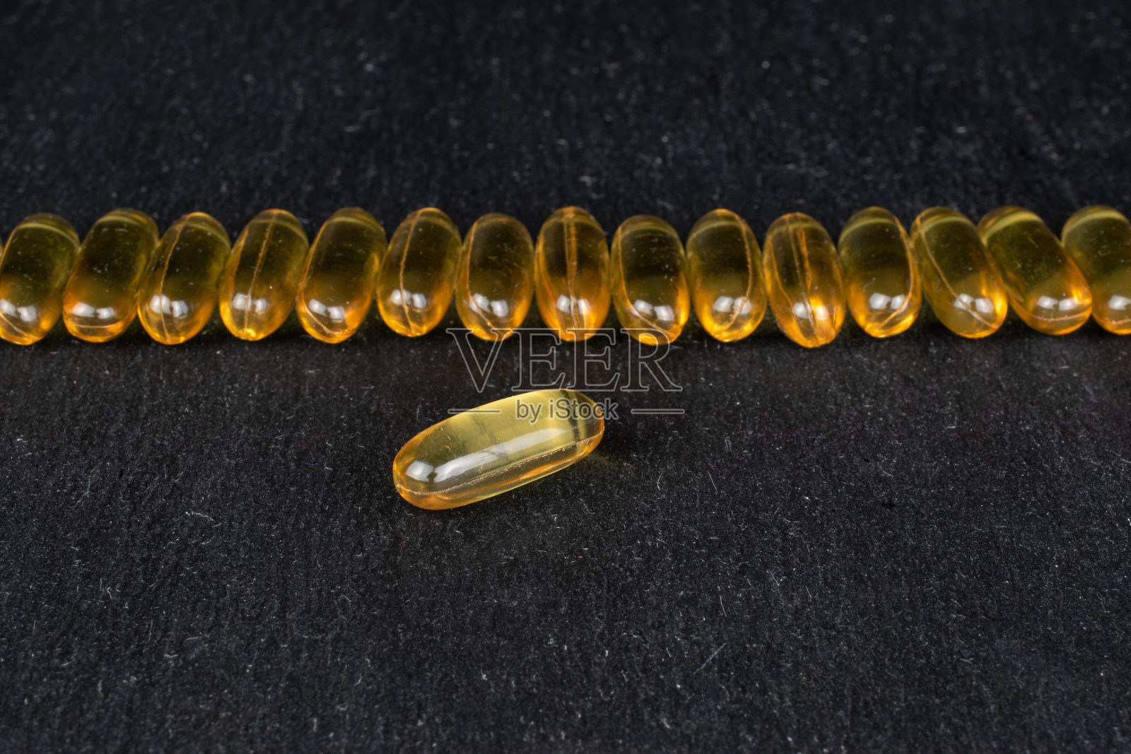 金色的鱼油在灰色的石头上照片摄影图片