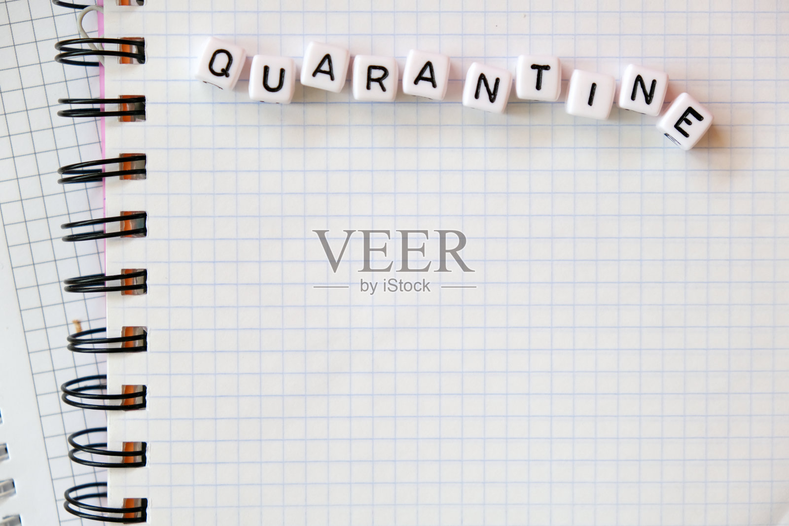 文字“检疫”，由立方体字母组成的单词在白纸便签本的背景上。照片摄影图片