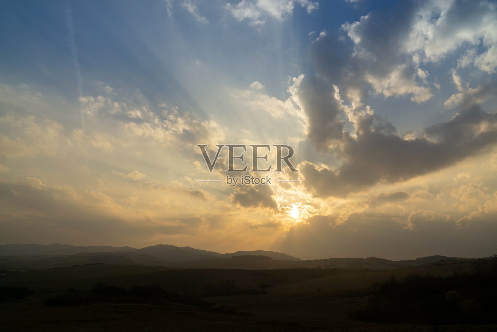 日出或日落在山丘和草地上。照片摄影图片