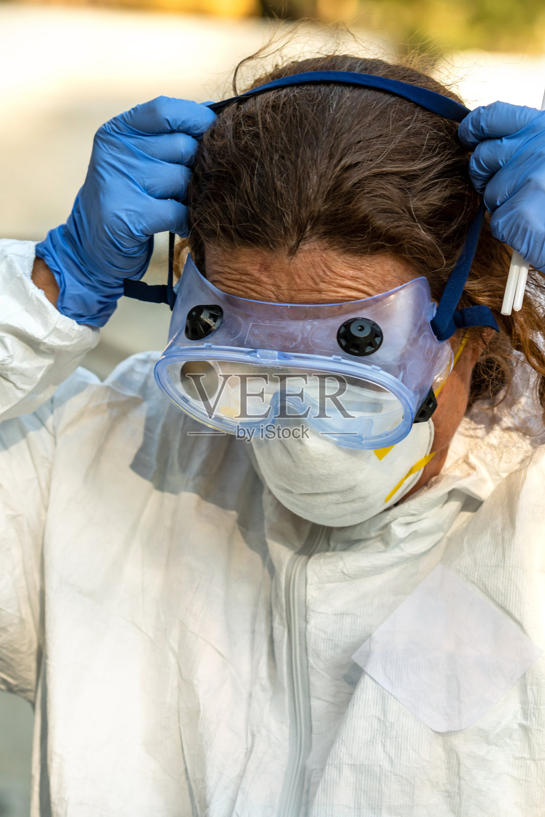 过度工作，女性成熟的卫生保健工作者穿着保护工作服照片摄影图片