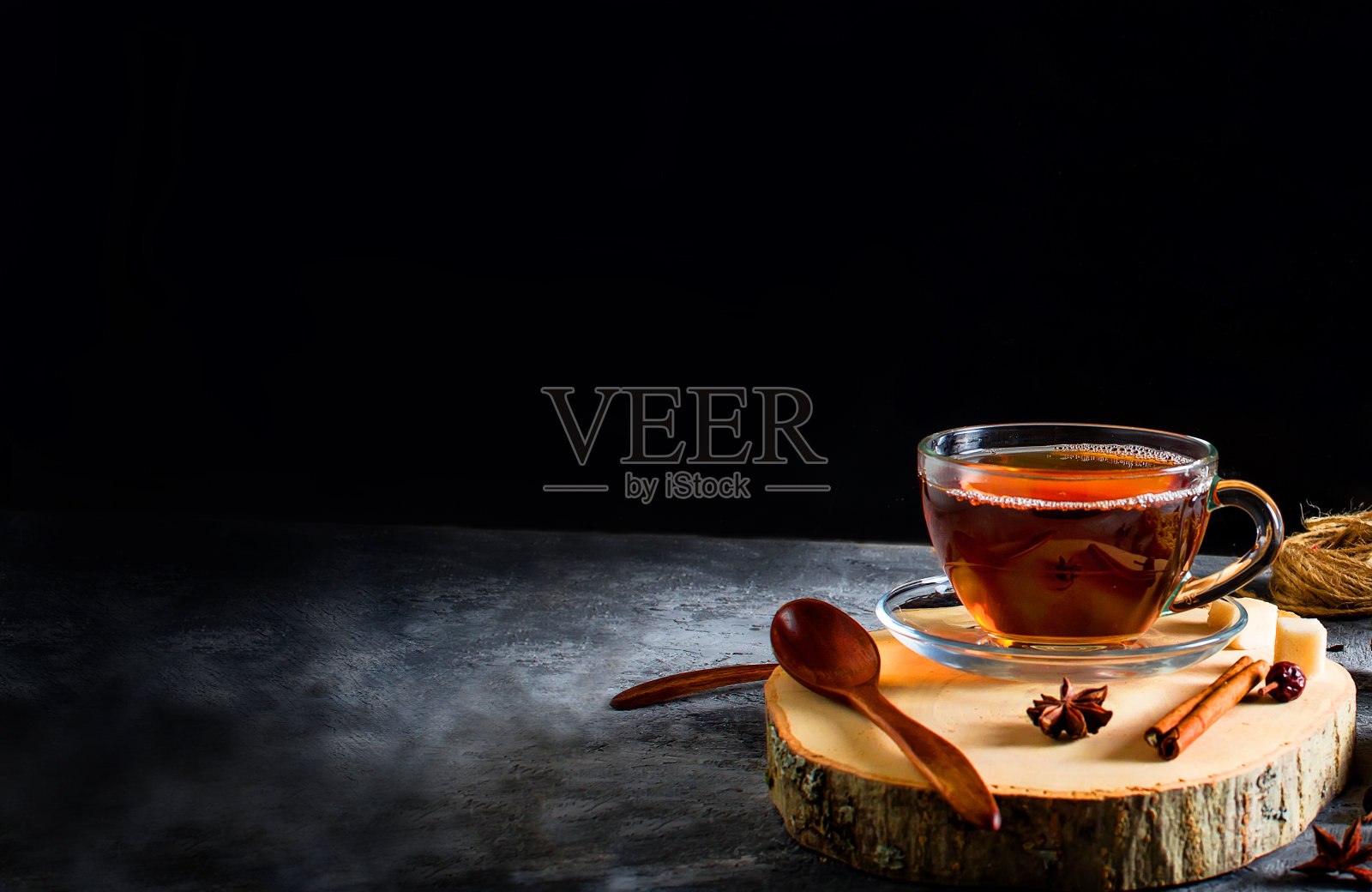 红茶在杯子上的黑色背景，茶杯茶，饼干，香料茶。照片摄影图片