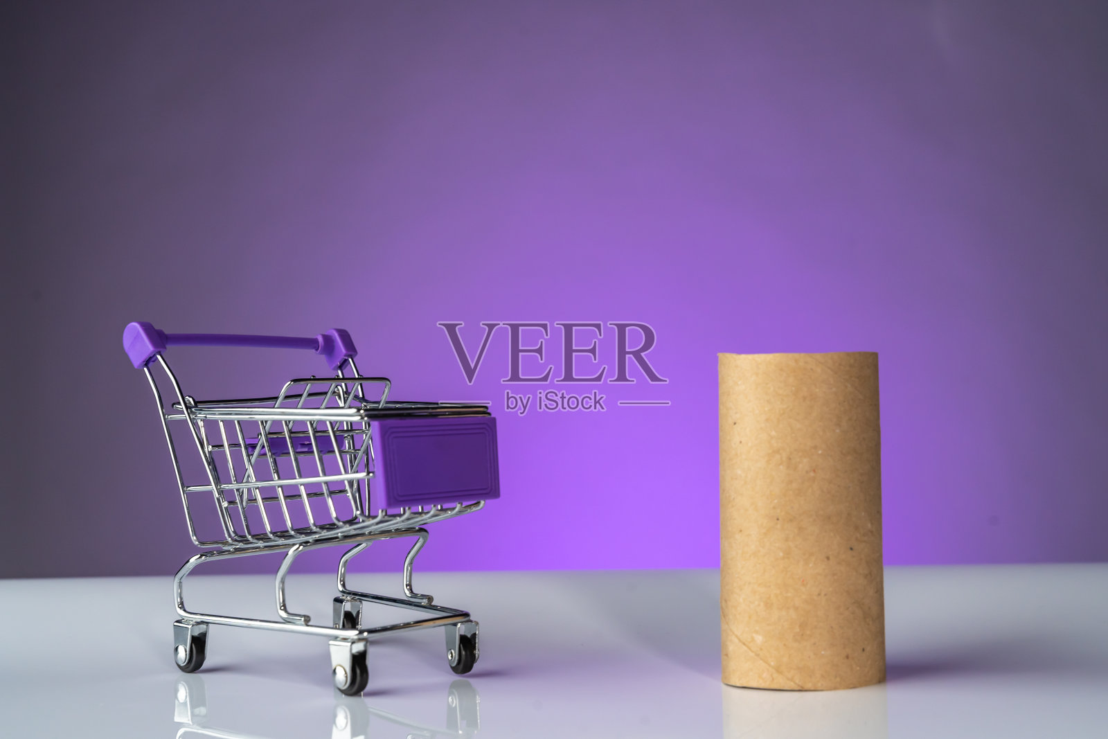 购物车和空卫生纸卷，紫色背景照片摄影图片