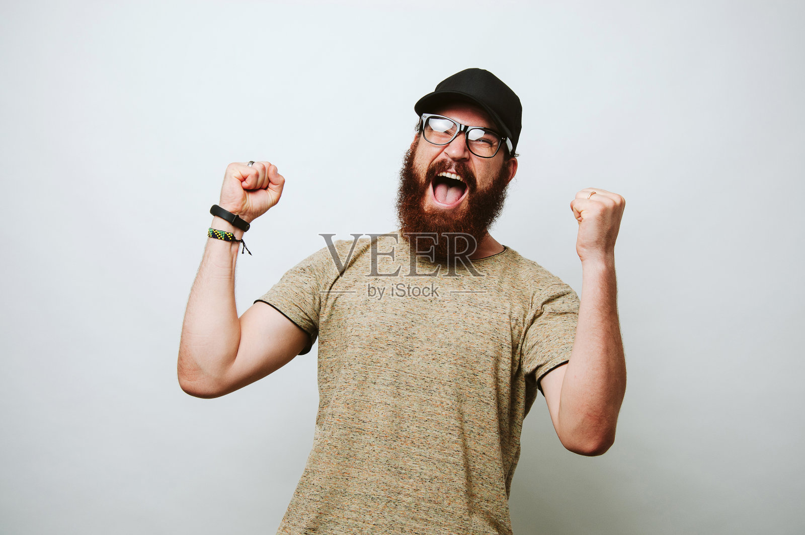 快乐惊奇的年轻胡子男人戴眼镜和庆祝成功照片摄影图片