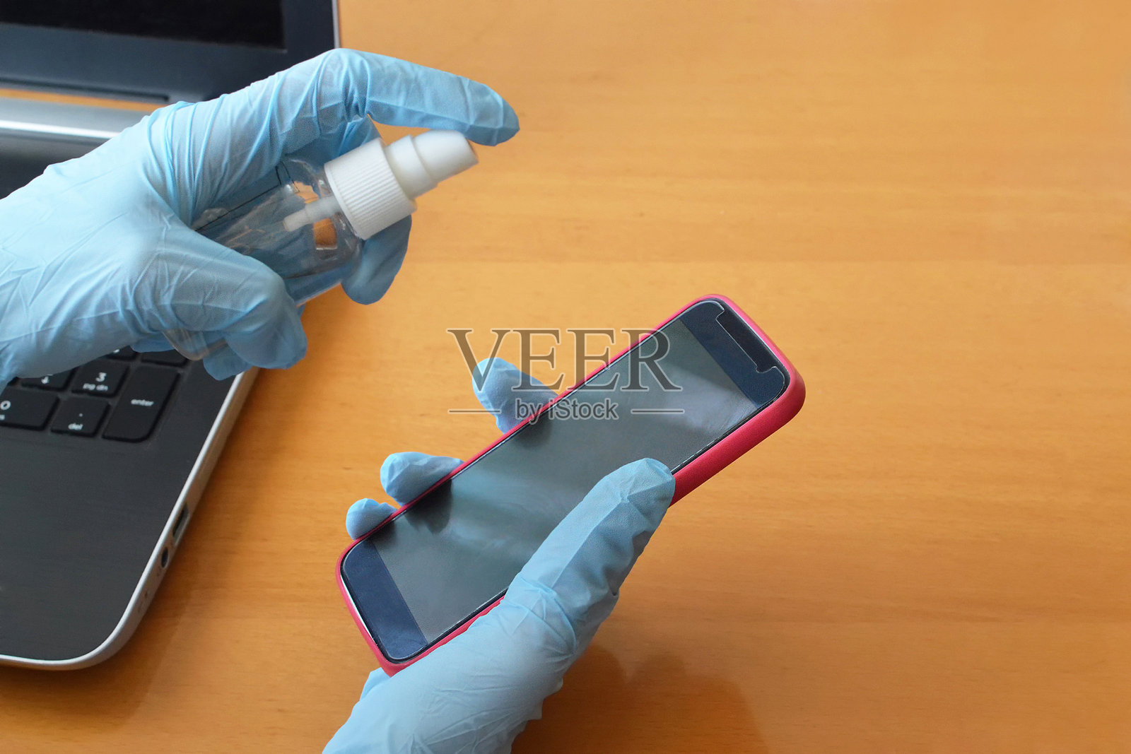 手戴手套给手机消毒。病毒防疫。病毒防护照片摄影图片