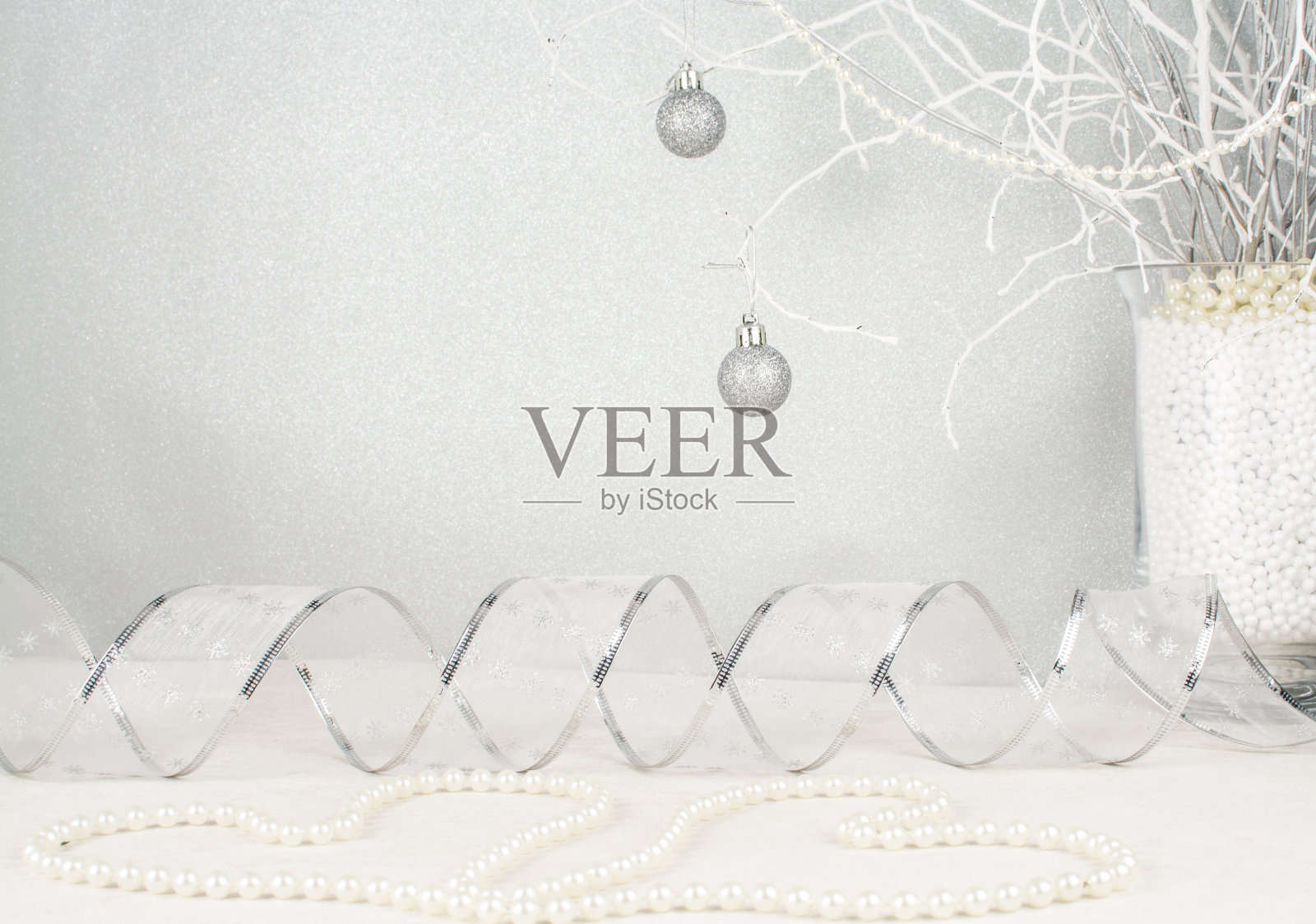 圣诞装饰在银色的背景与银丝带和珍珠心照片摄影图片