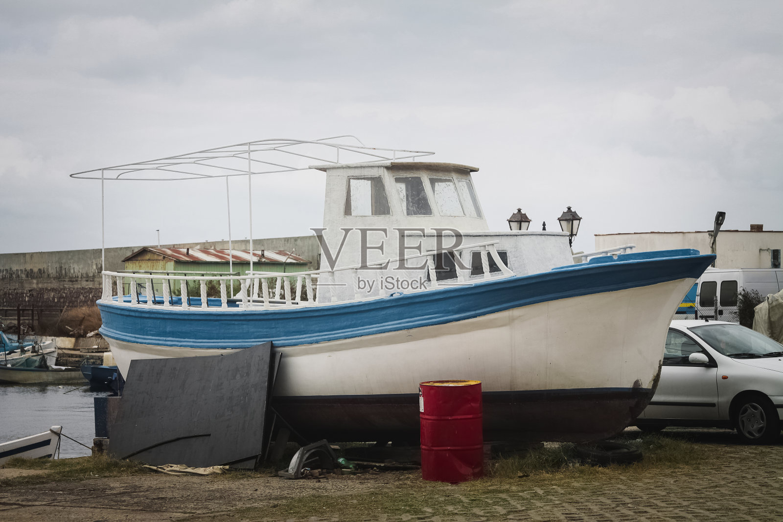 旧渔船停泊在码头等待修理。照片摄影图片