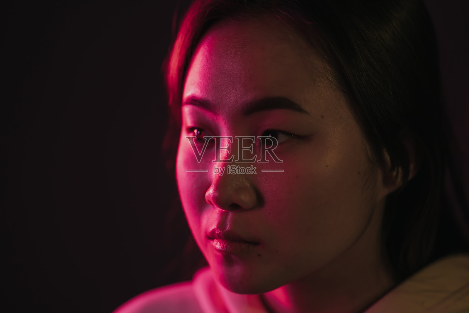 特写的千禧漂亮的韩国女人的长发与霓虹灯。工作室里的潮人照片摄影图片