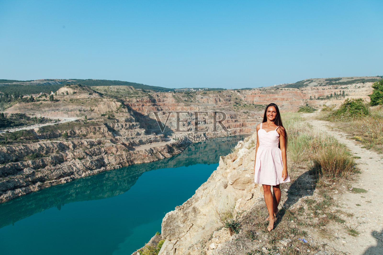 一个长发女子站在湖边的山上照片摄影图片
