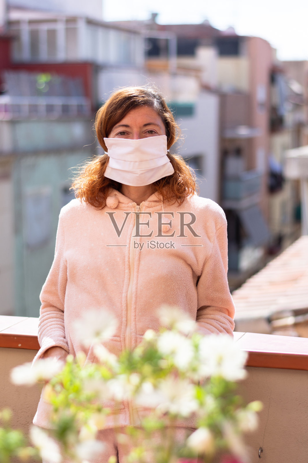 戴口罩的妇女被限制在家，在露台上呼吸空气照片摄影图片