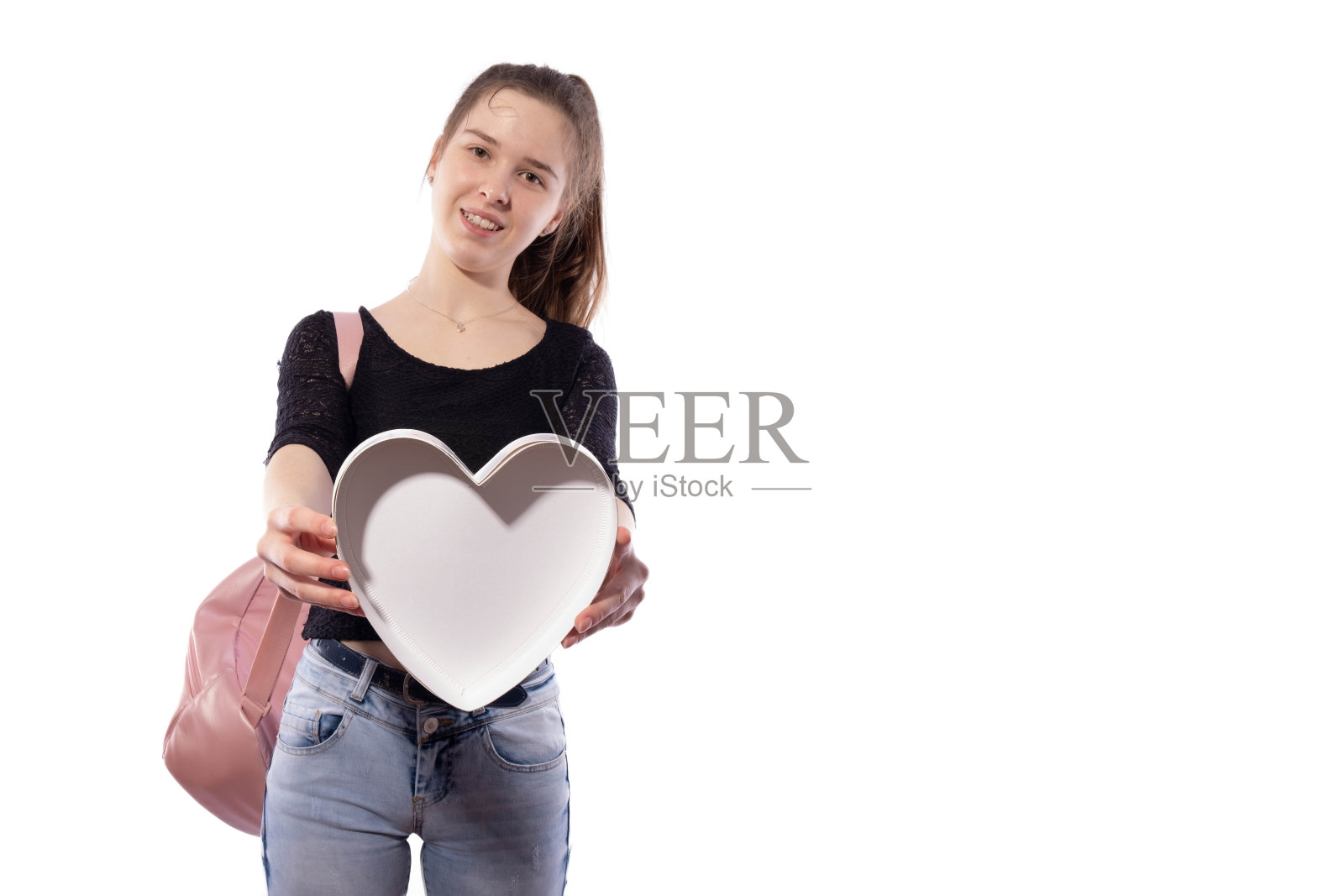 女孩微笑着，拿出一颗纸心照片摄影图片