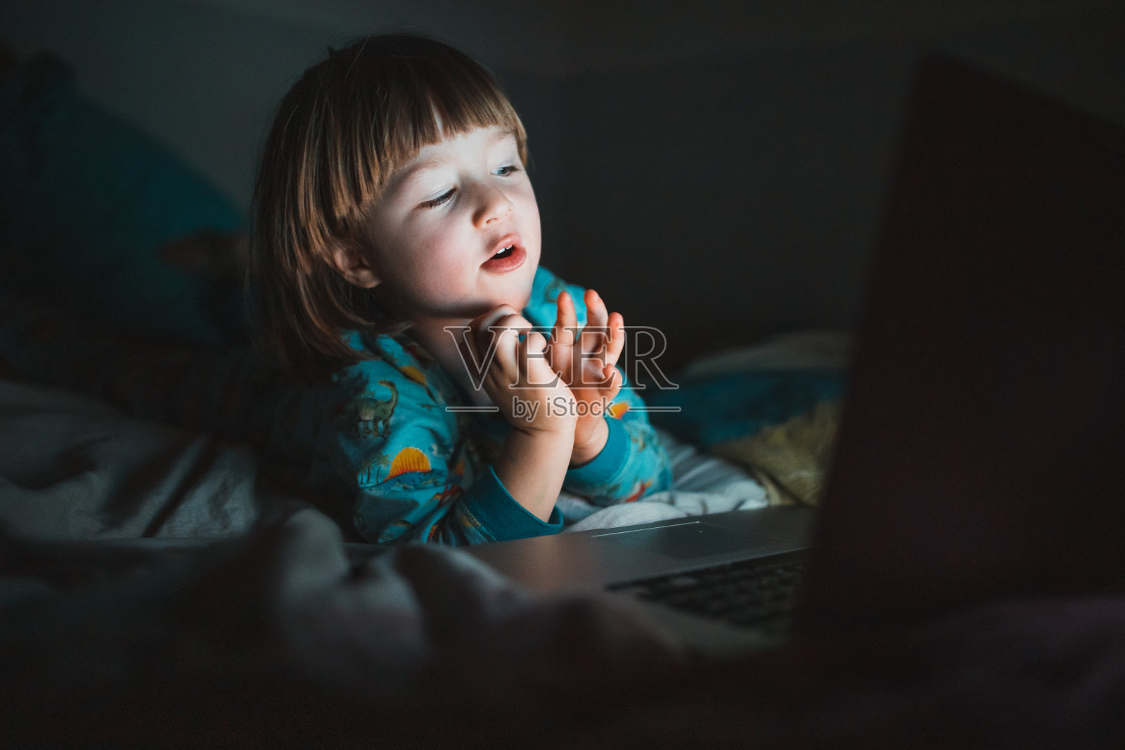 蹒跚学步的小男孩在家里看动画片照片摄影图片