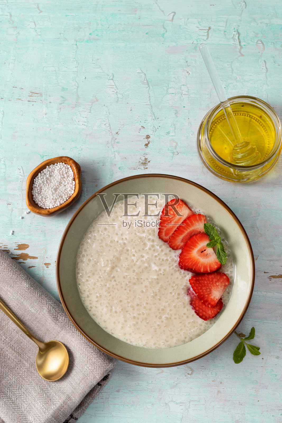 垂直拍摄的盘子与素食木薯布丁在浅绿松石背景照片摄影图片