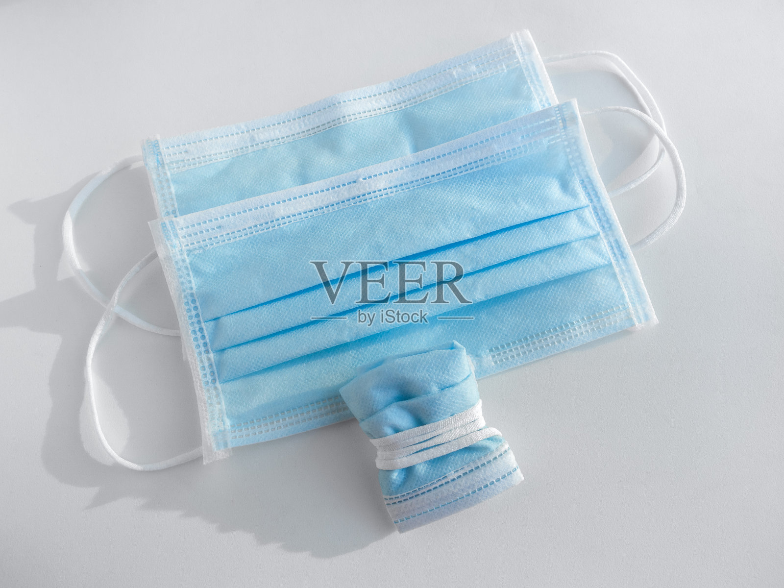 使用掩码的概念。在乱扔垃圾前将使用过的防护口罩折叠起来，以防止病毒传播。照片摄影图片